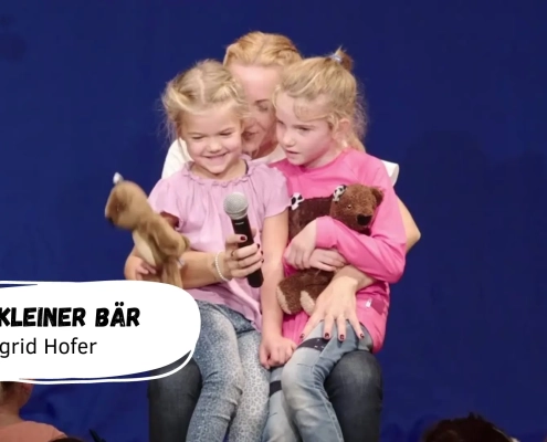 Kinder mit Plüschbären auf der Bühne.