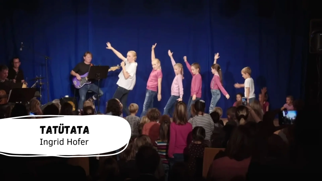 Kinder tanzen auf einer Bühne.